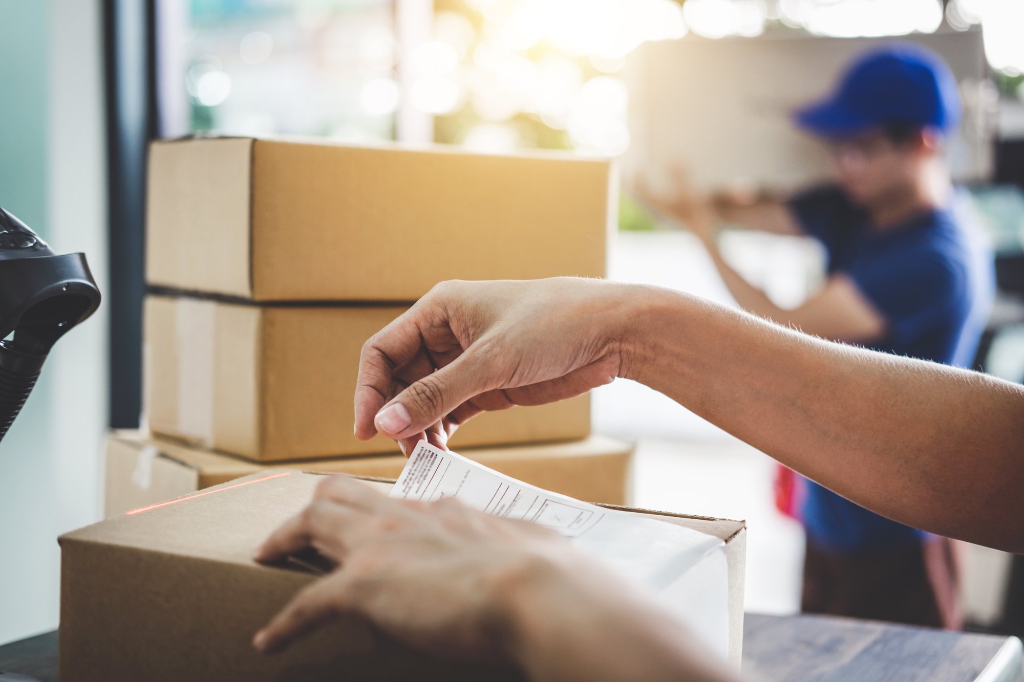 A shipping label being applied to a parcel ahead of despatch