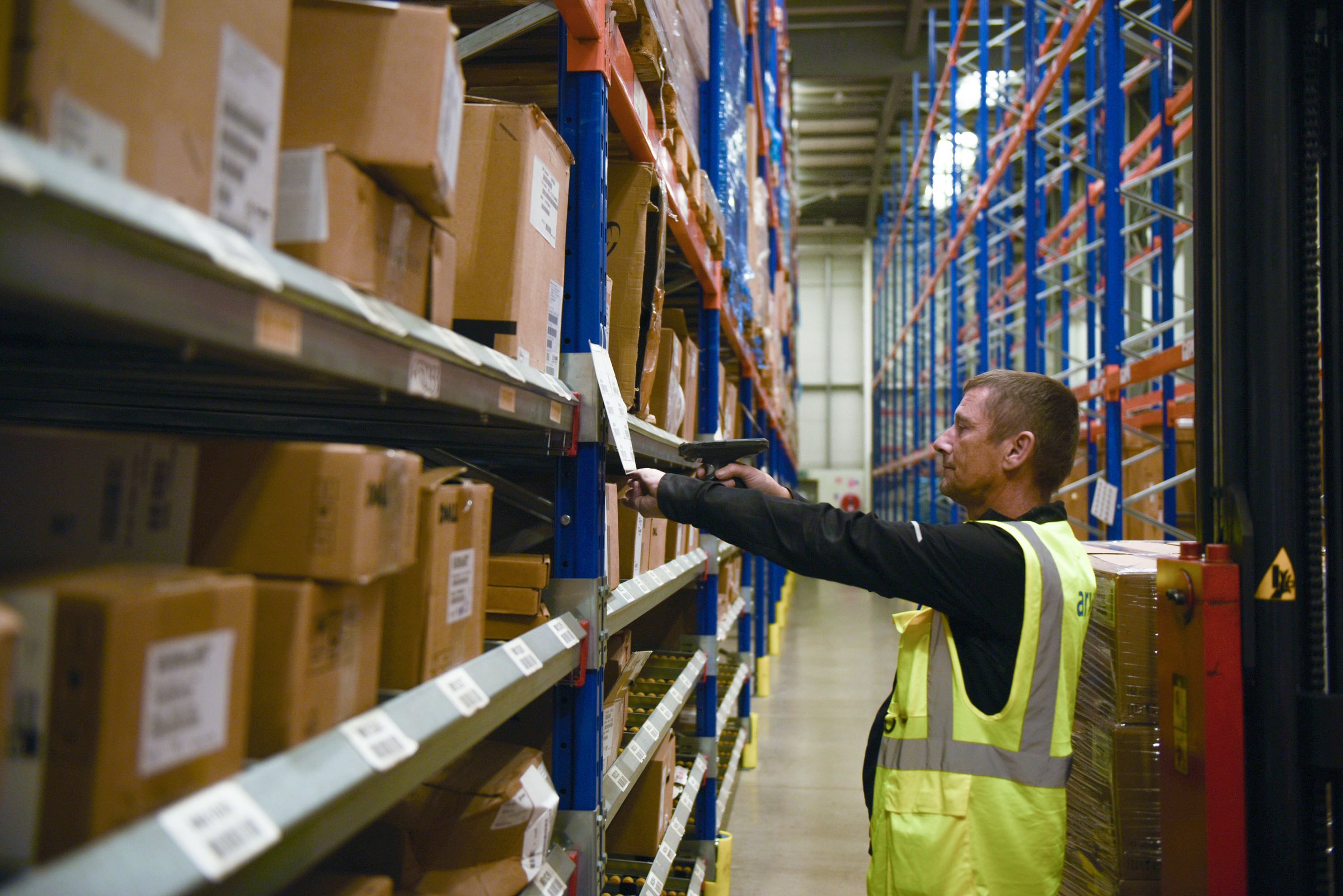 A warehouse operative scanning a shelf label in the Swords facility